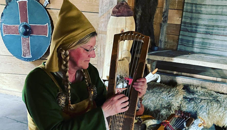 Kvinna spelar på ett instrument från Vikingatiden
